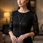 Stylová žena v černých krajkových šatech s jemnými zlatými šperky drží malou kabelku v elegantním interiéru