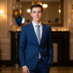 Mladý muž ve večerním obleku na oslavě narozenin v elegantním prostředí s balónky a dekoracemi.