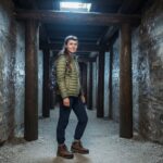 Mladá žena ve vstupu do solného dolu Wieliczka v praktickém oblečení připravená k průzkumu.